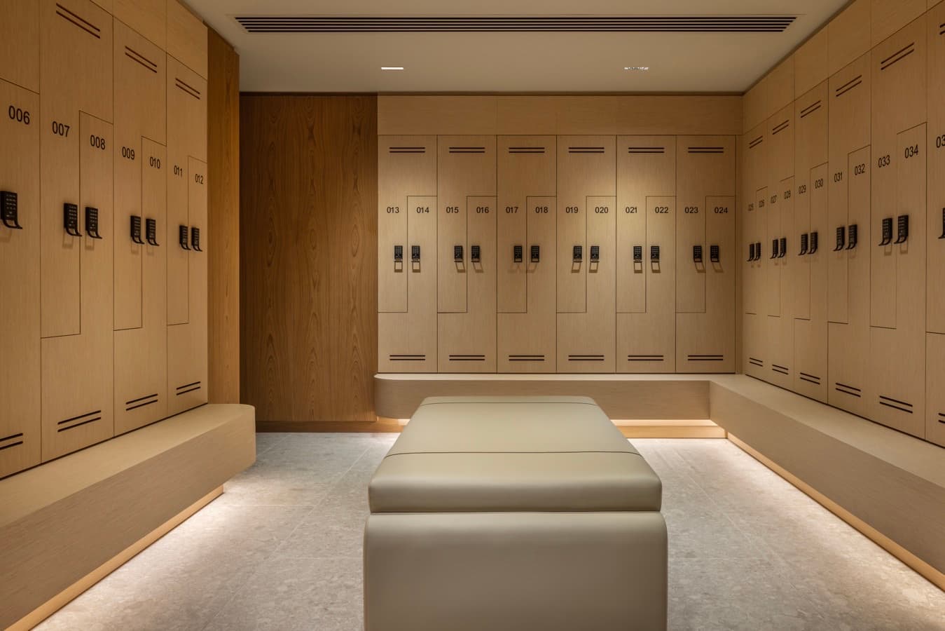 Wide view of the numbered oak lockers around a lit bench