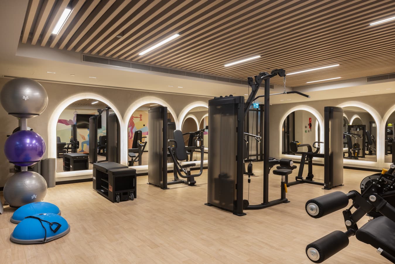 Gym area with balance balls, cable machines and illuminated arches