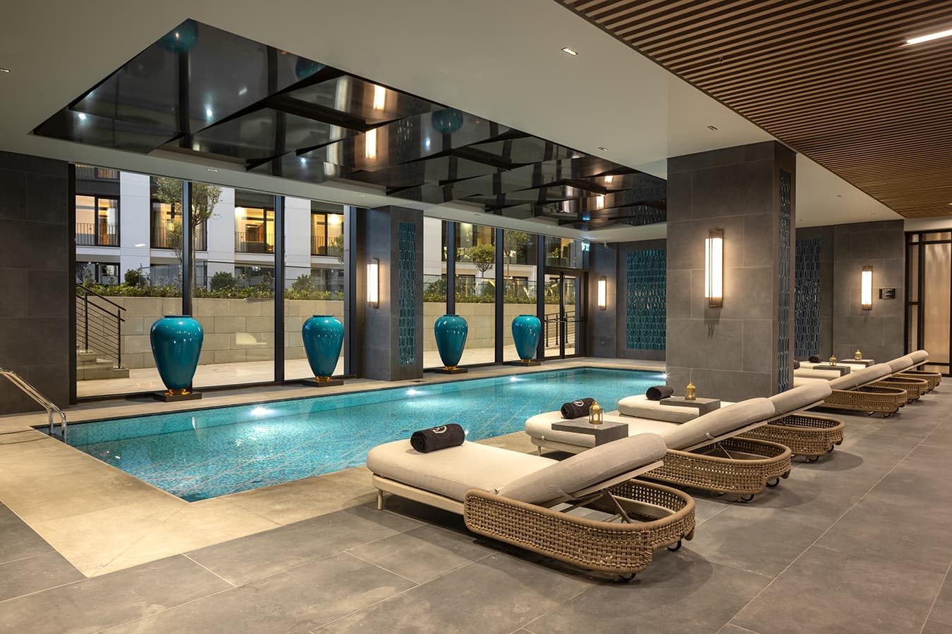 Indoor pool with turquoise vases and loungers along the glass wall at Navitas Spa Hilton Istanbul Airport
