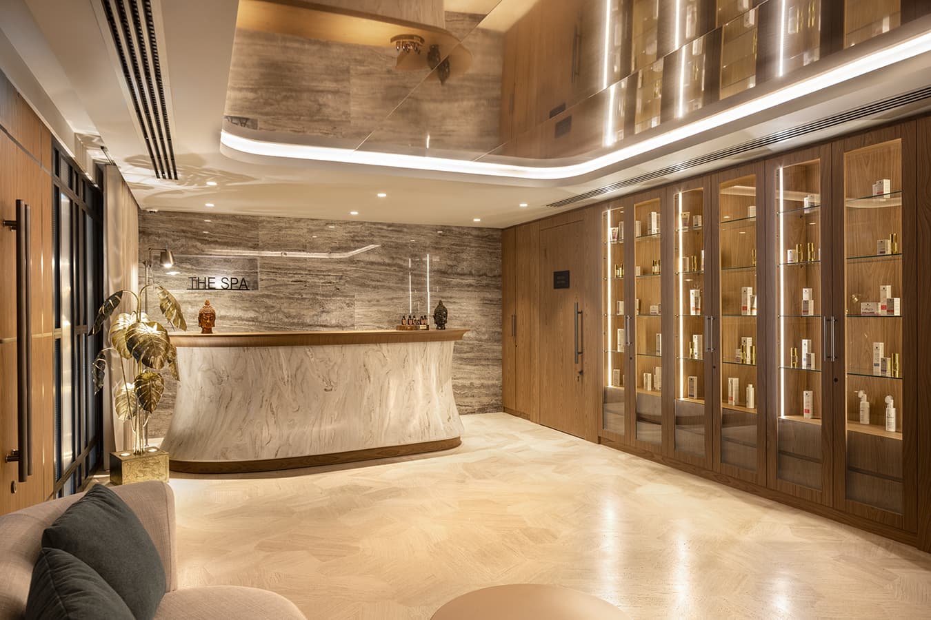 The Spa reception desk in marble and wood beside backlit product display cabinets