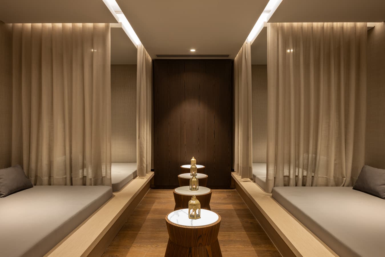 Quiet relaxation lounge with curtained alcoves, daybeds and candle-lit wooden stools
